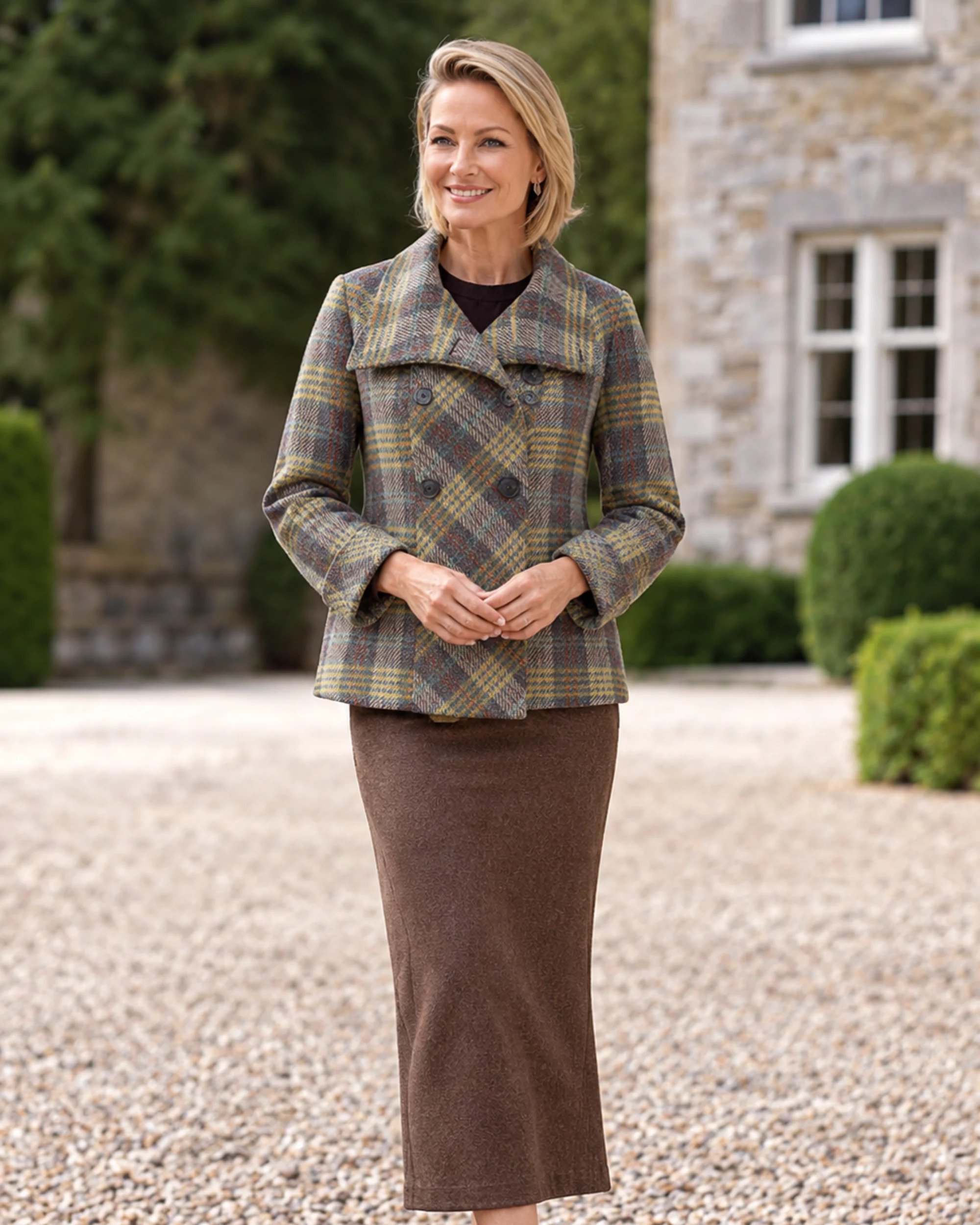 1 Woman wearing a multicolour checked tweed jacket with a wide collar and double-breasted buttons, styled with a brown midi skirt.